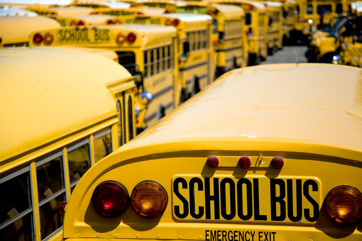 A fleet of school buses lined up at a depot